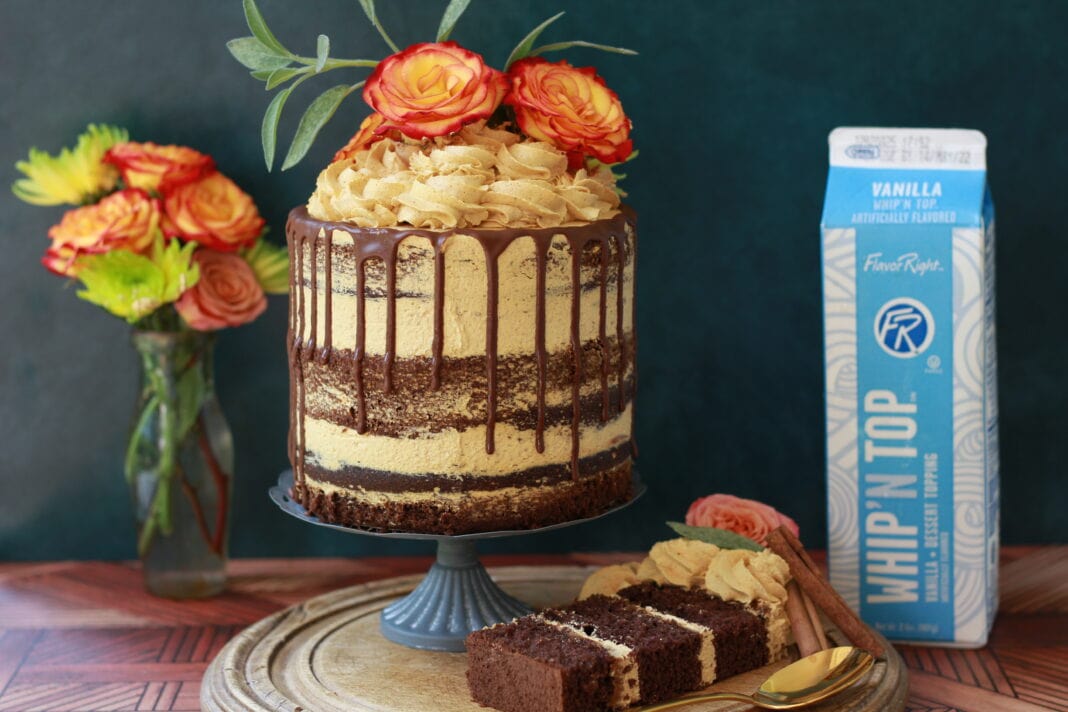 Chocolate layer cake filled with pumpkin mousse, finished with a chocolate drip and topped with buttercream swirls and orange roses.