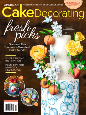 American Cake Decorating July/August 2026 magazine cover featuring a peach-inspired tiered cake decorated with sugar flowers, modeling chocolate peaches, and summer cake decorating trends.