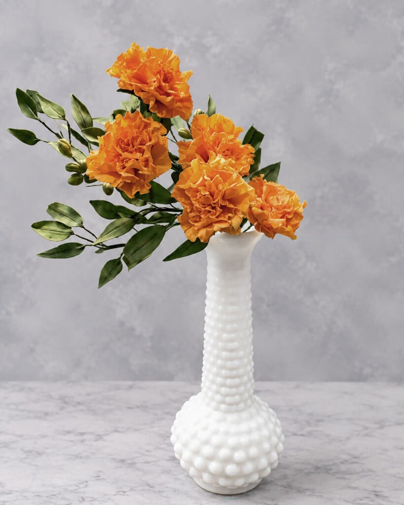 orange gum paste marigold flowers in a vase